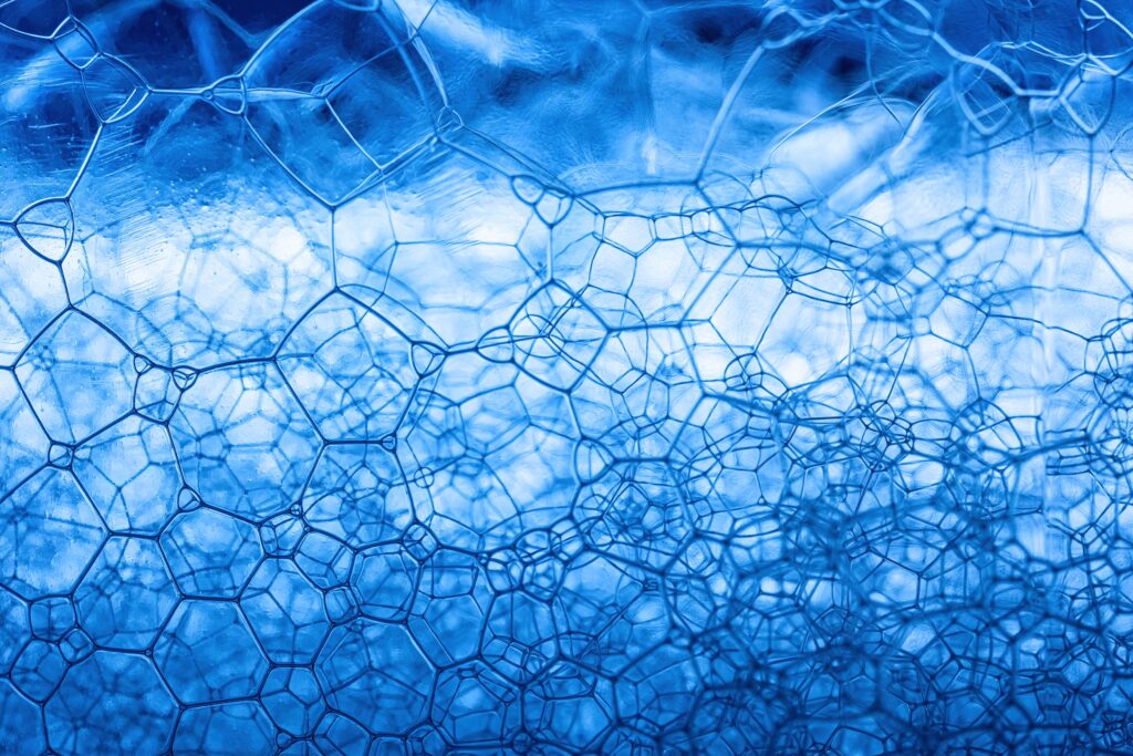 surfactants Detailed close-up of blue soap foam showcasing abstract geometric patterns and texture.